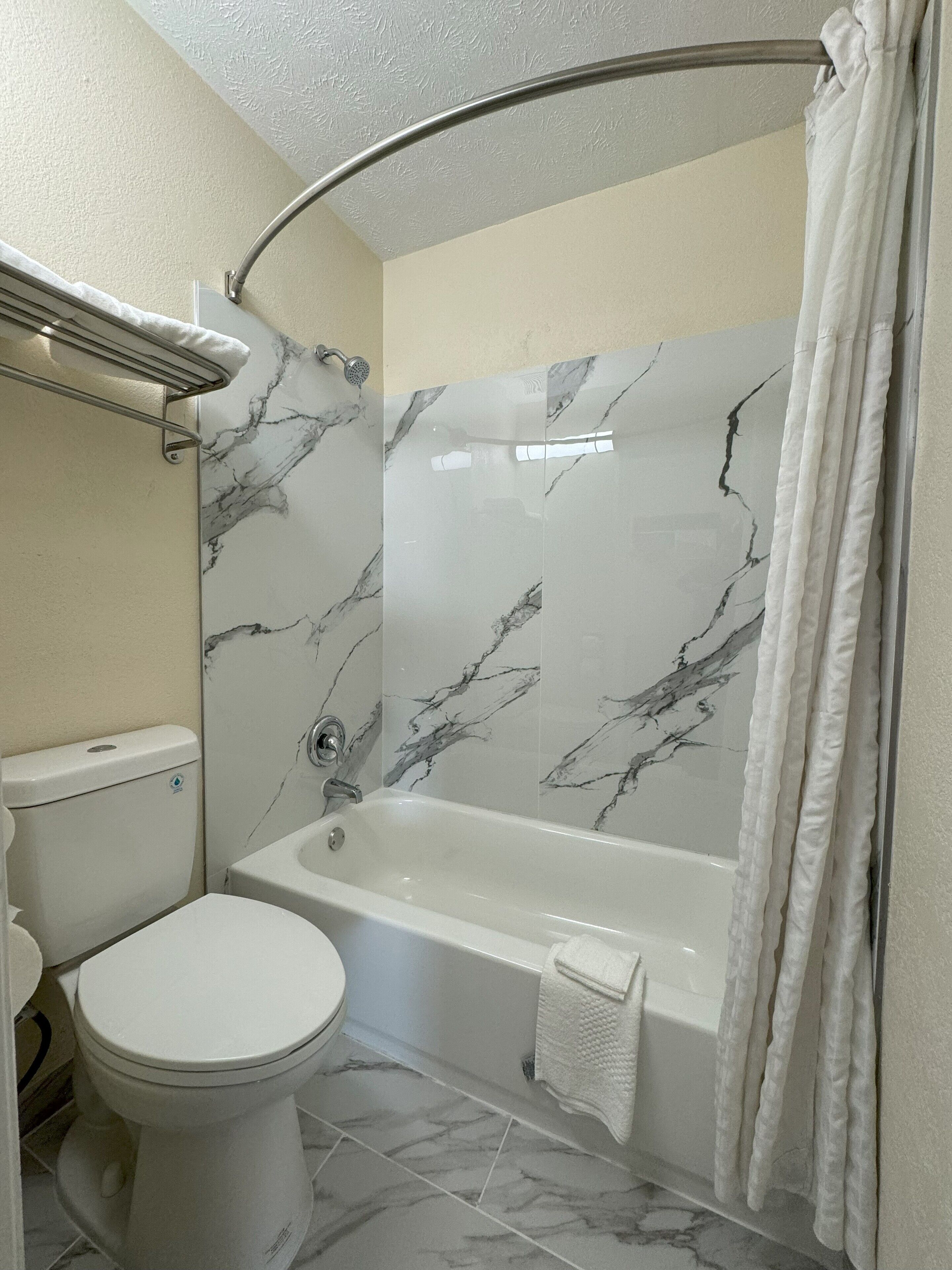 A bathroom with a toilet, bathtub, and shower curtain.