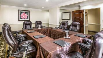 Conference room with a long table and eight leather chairs, a carpeted floor, and a framed artwork on the wall.