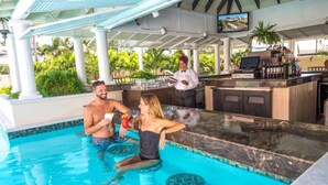 Zona de piscina con bar y camarero.
