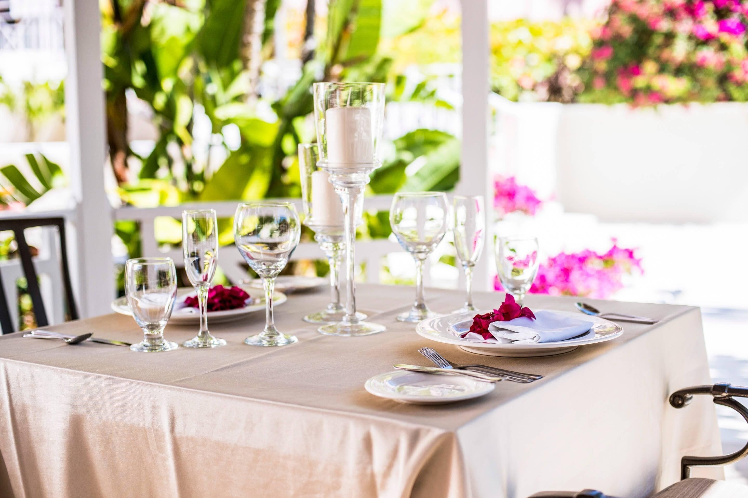 A table set for dining with clear glassware, plates, and a candle centerpiece.