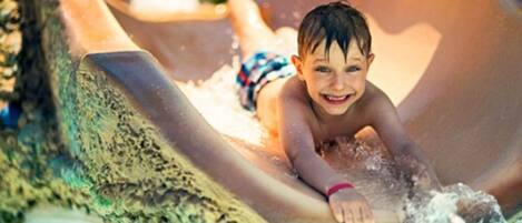 Un niño resbalando por un tobogán de agua.