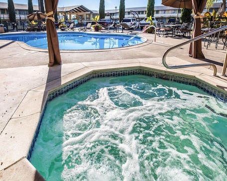 Una piscina al aire libre, sombrillas, sillones reclinables de piscina