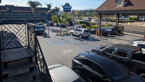 Ein Parkplatz mit mehreren Autos, einem Schild für Cabana Inn & Suites und einem Gebäude im Hintergrund.