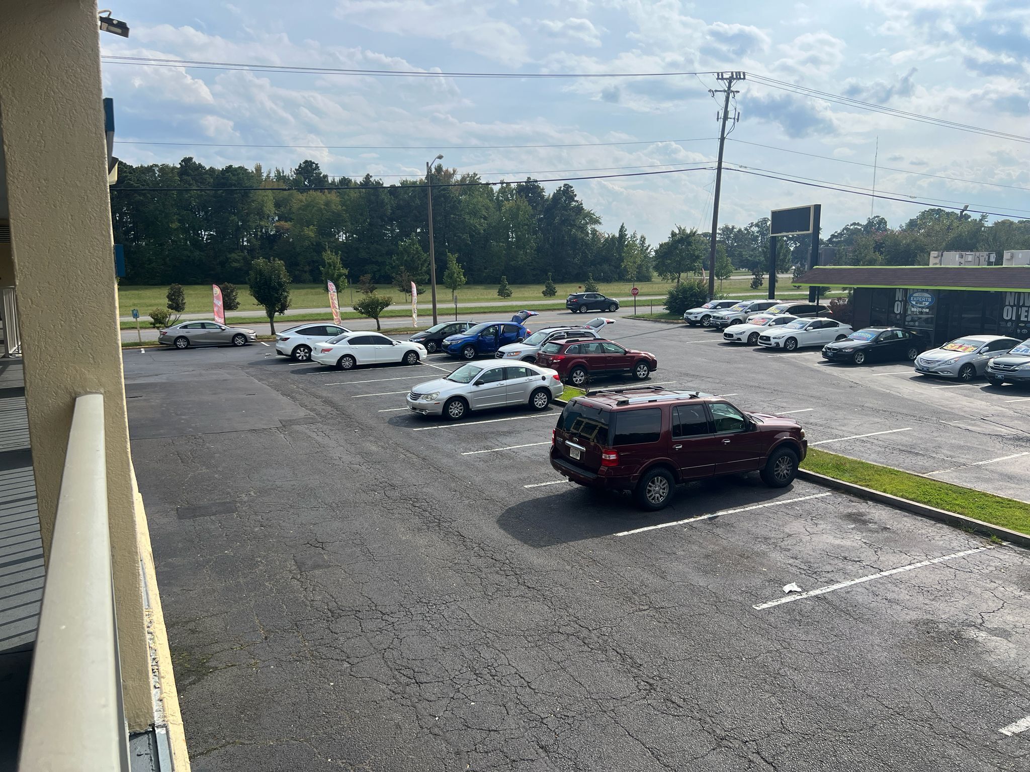 A parking lot with multiple cars and a building in the background.