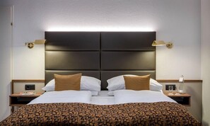 Ropa de cama hipoalergénica y caja de seguridad en la habitación 