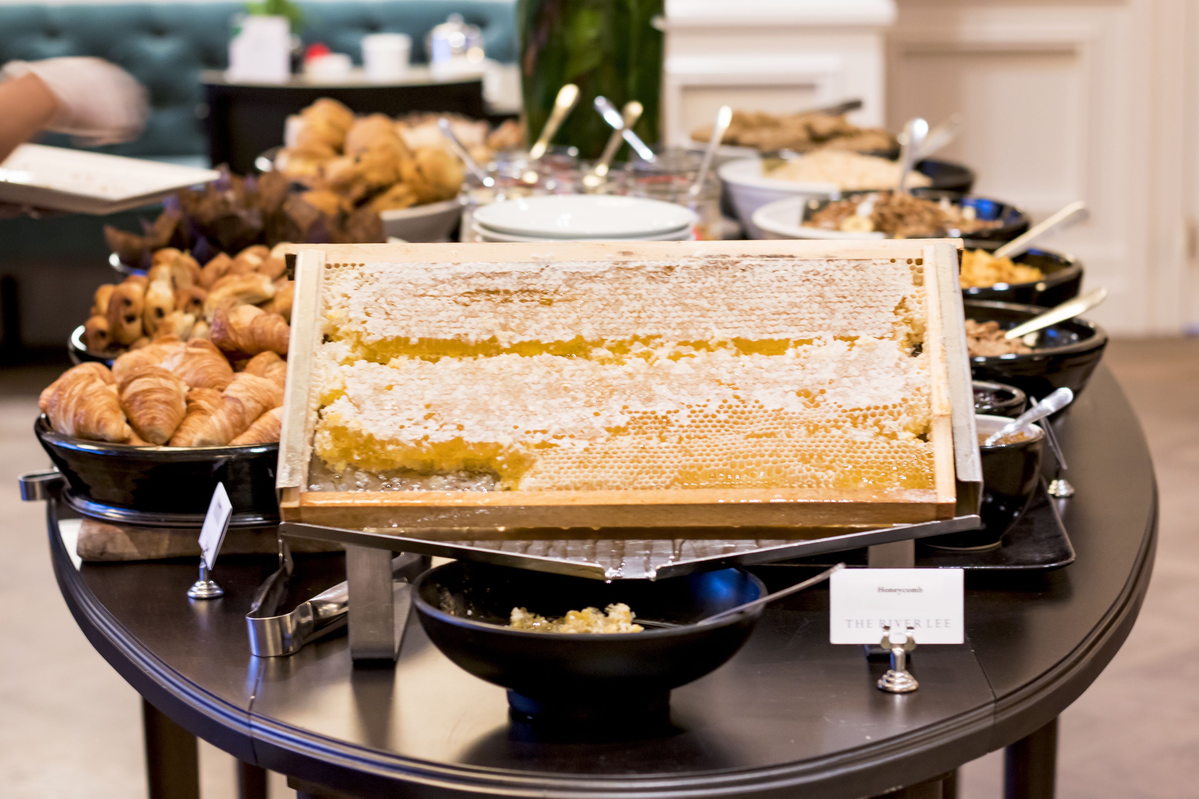 A buffet table with various food items including pastries and a honeycomb display.