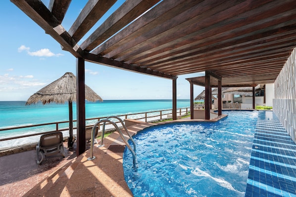 Una piscina al aire libre, sombrillas, tumbonas