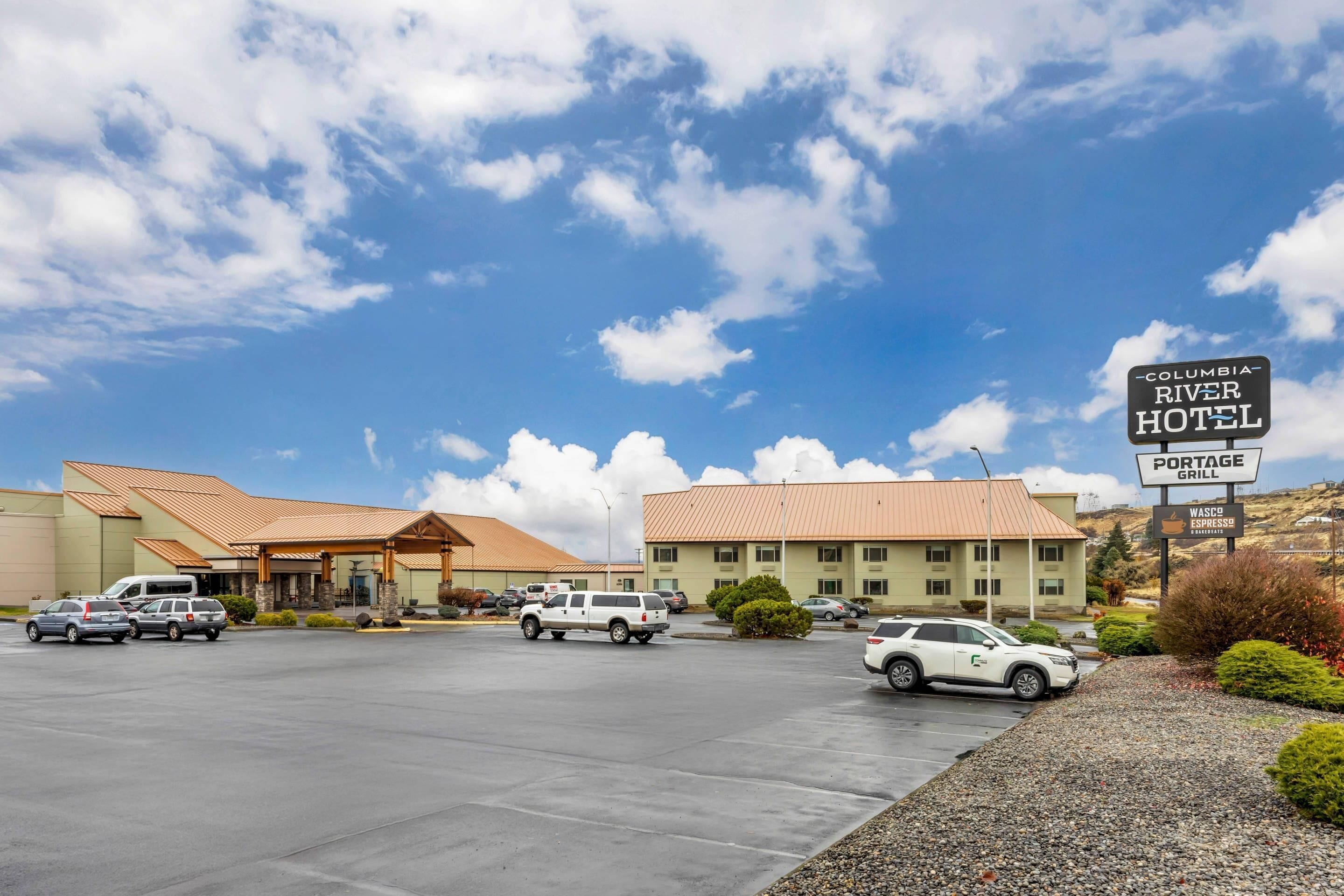 Un hôtel doté d’un parking, d’un espace abrité et d’une enseigne indiquant le « Columbia River Hotel ».