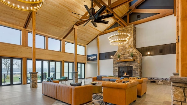 A spacious living area with a stone fireplace, large windows, and a high ceiling with exposed beams. - Columbia River Hotel and Conference Center, an Ascend Collection Hotel (The Dalles)