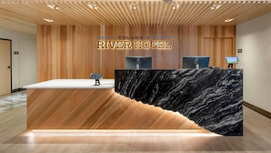 A reception desk at Columbia River Hotel with a wooden panel design and a marble counter. - Columbia River Hotel and Conference Center, an Ascend Collection Hotel (The Dalles)