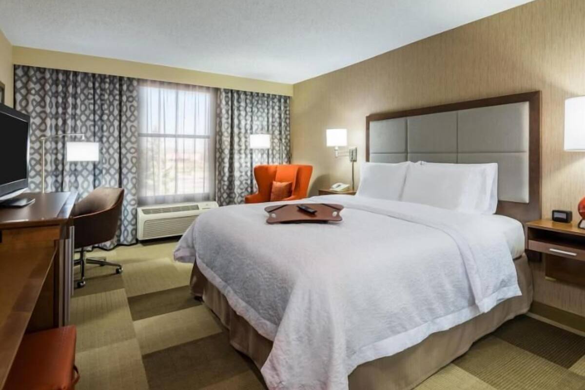 Une chambre d’hôtel équipée d’un lit, d’un bureau, d’une chaise et d’un téléviseur.