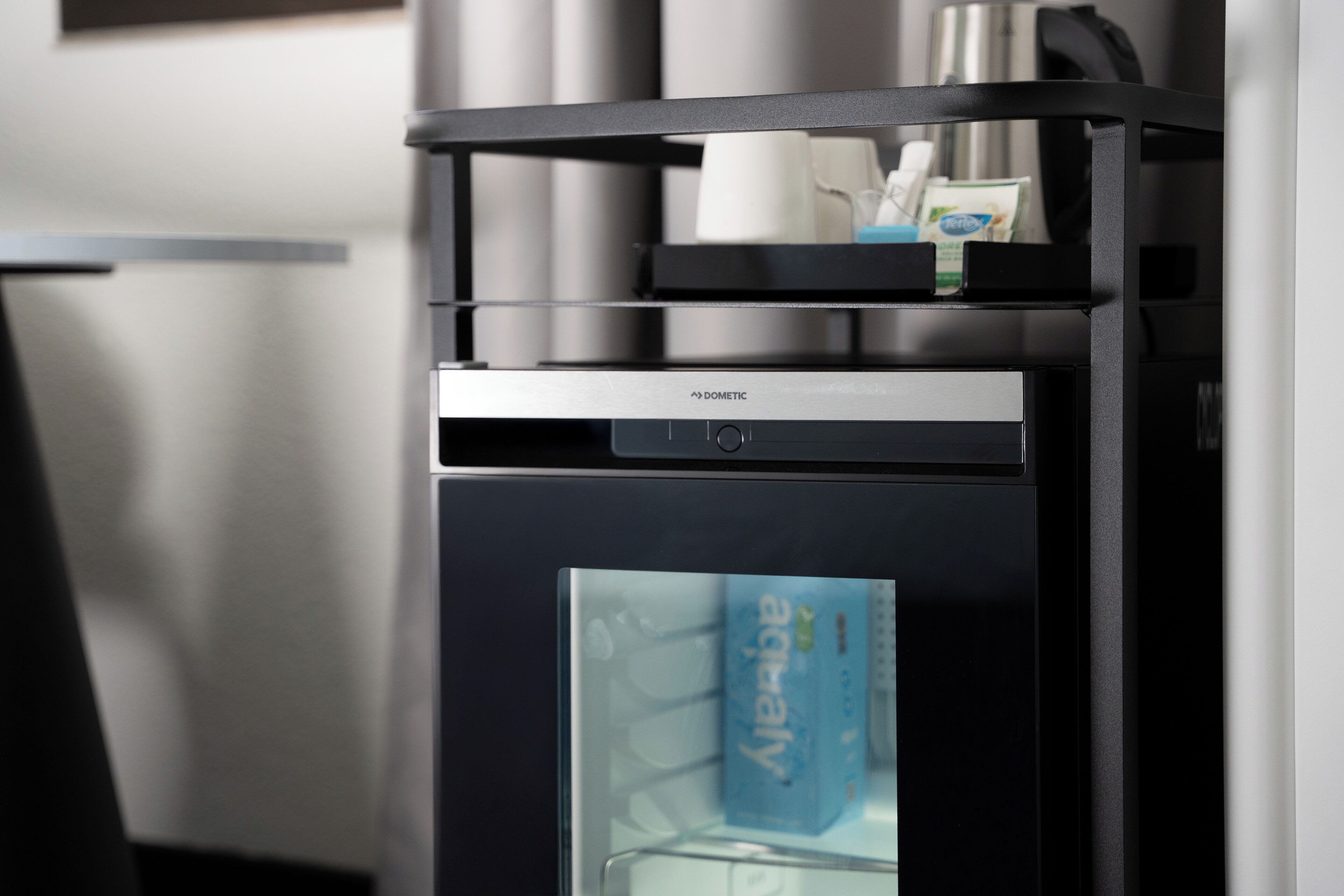 A modern coffee machine with a glass display, a coffee cup holder, and a Dometric brand label.