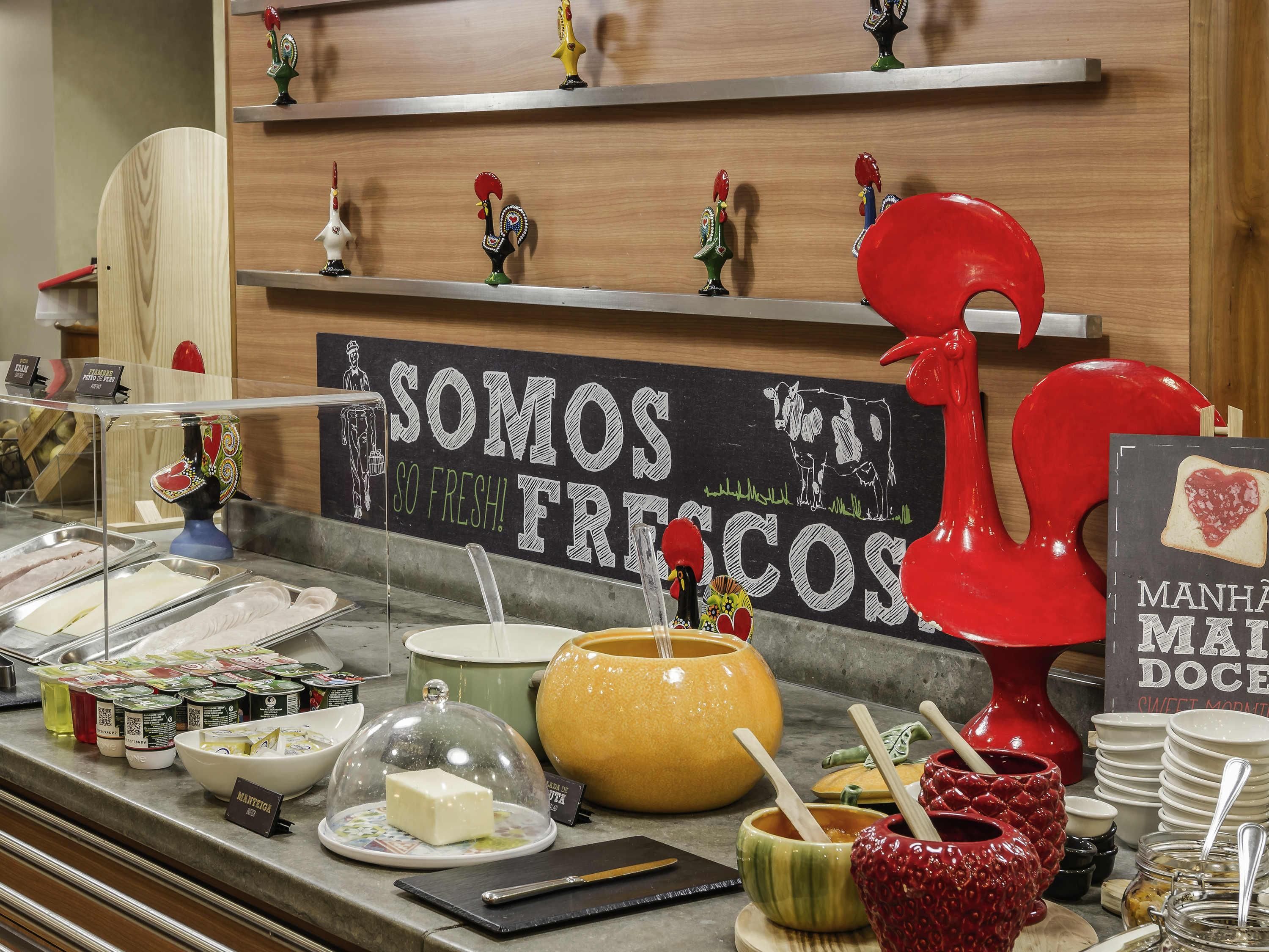 A breakfast buffet with various food items and a sign that reads 'SOMOS VAINOS FRESCOS'.