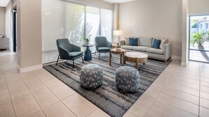 A modern living room with a grey sofa, two armchairs, a coffee table, and a rug. - Quality Inn & Suites Hermosa Beach (Hermosa Beach)