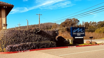 A sign for The Miramar Inn, a fire lane, and a building with a tiled roof.