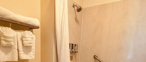 A bathroom with a toilet, a shower with a glass door, and a bathtub.