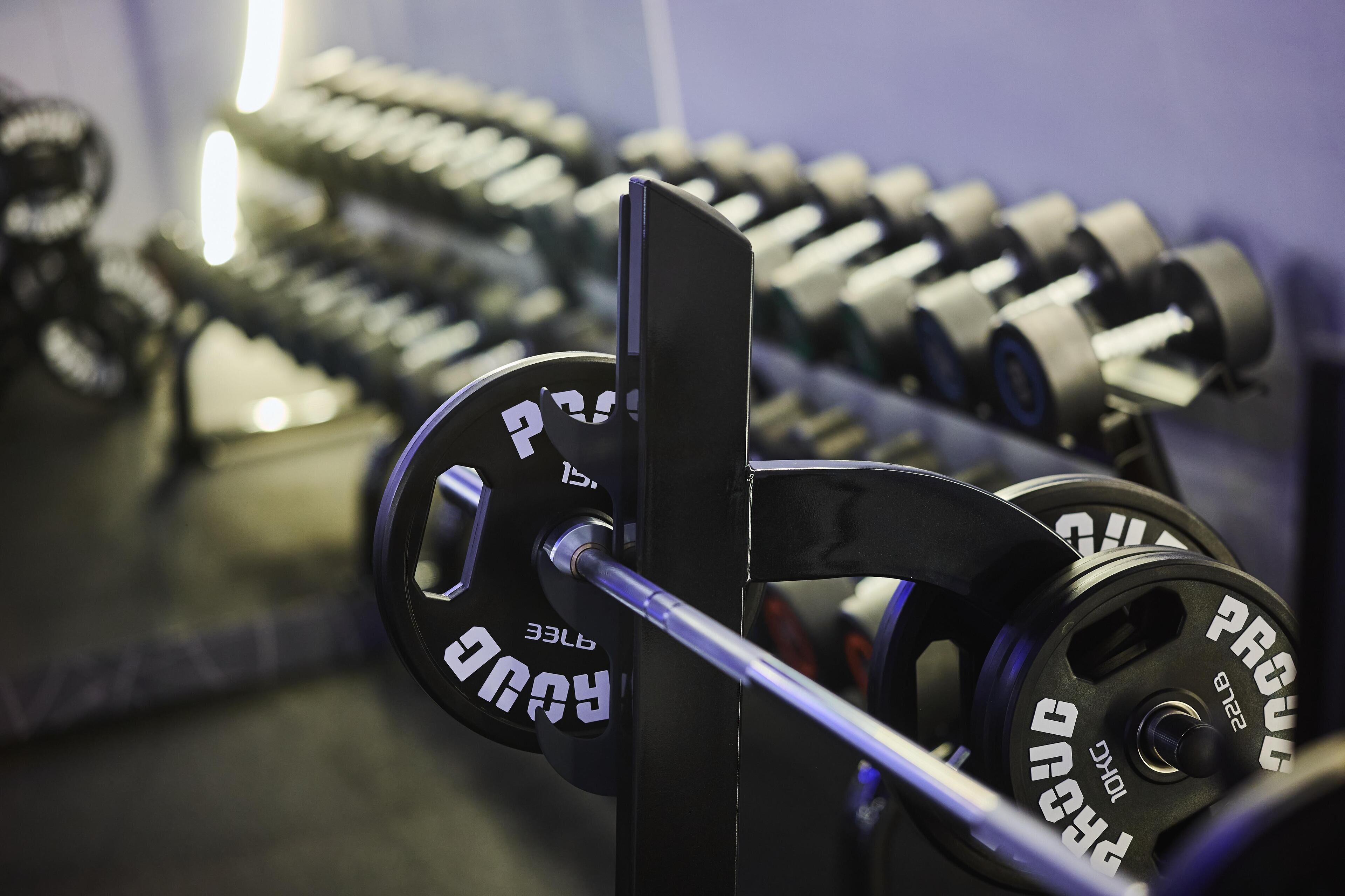 A rack of dumbbells with weight markings, indicating a gym setting.
