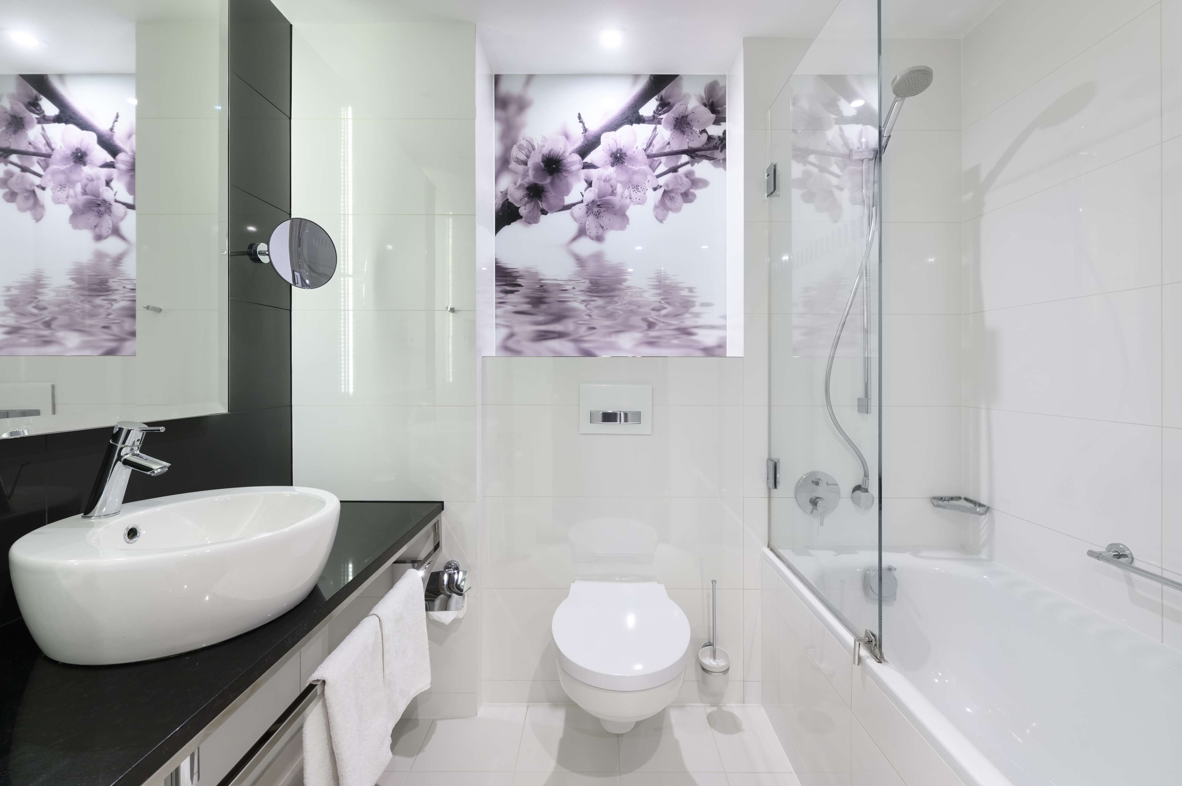 A modern bathroom with a white sink, toilet, and bathtub.