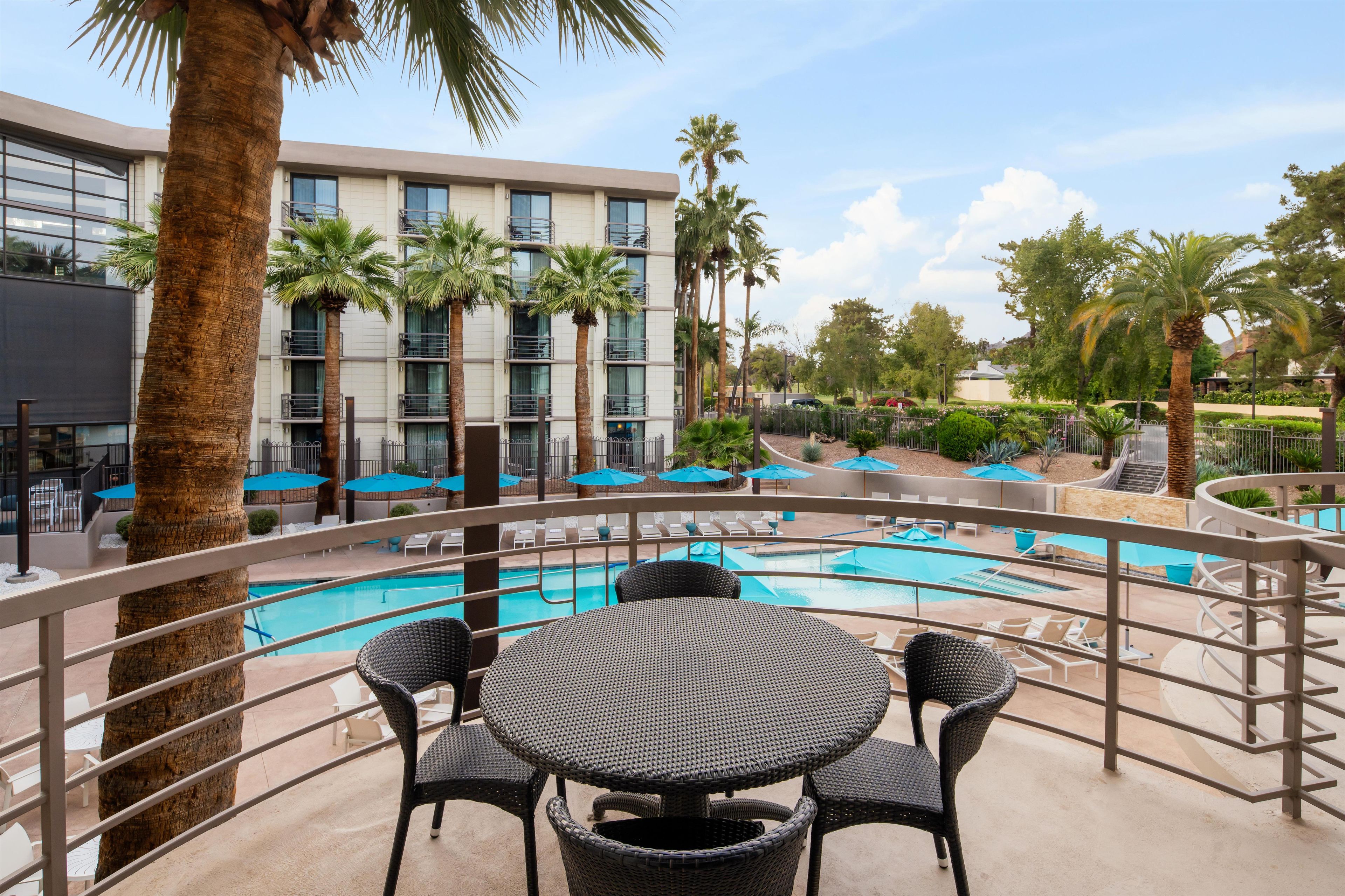 Zona de piscina d'hotel amb diverses piscines, gandules i ombrelles.