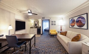 A hotel room with a dining area, a sofa, a desk, and a kitchenette. - Embassy Suites by Hilton Phoenix Biltmore (Phoenix)