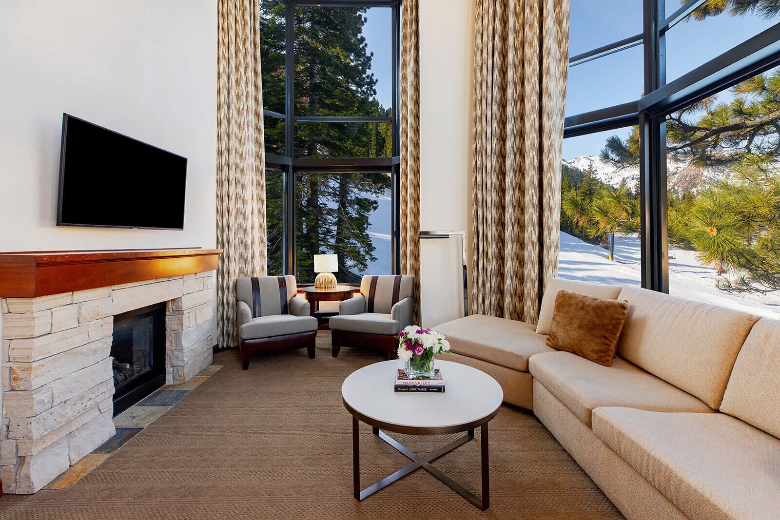 A modern living room with a fireplace, a television, a sofa, and a coffee table.