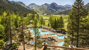 Un resort con varias piscinas, un campo de golf y paisajes montañosos.
