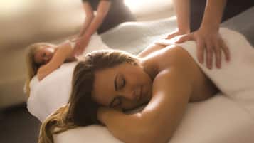 Een massagesessie in een ruimte met een massagetafel en een persoon die een rugmassage ontvangt.