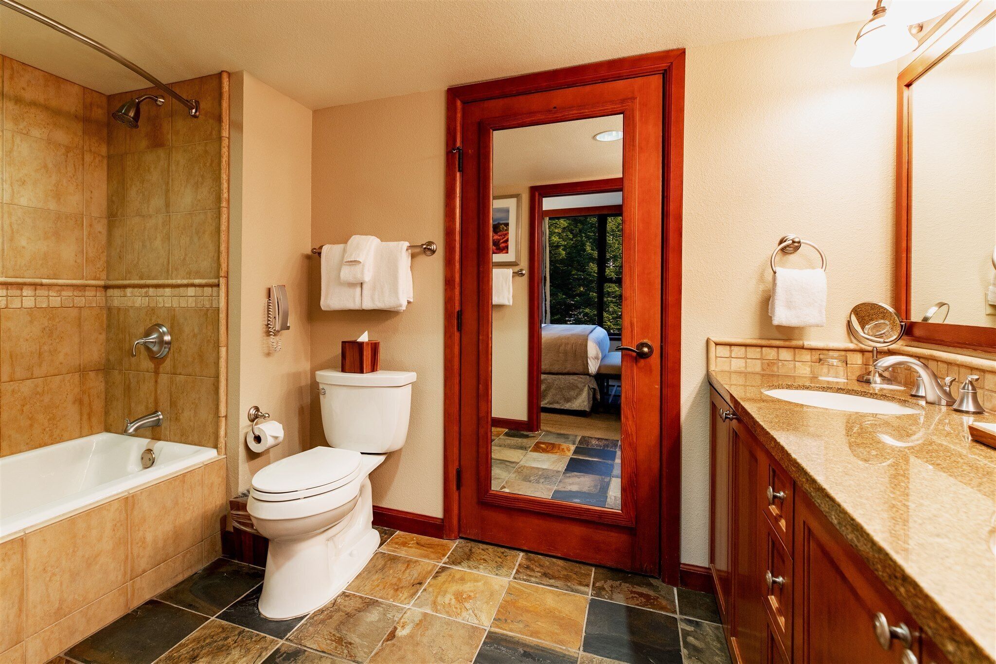 A bathroom with a bathtub, toilet, and sink.