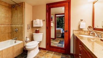 A bathroom with a bathtub, toilet, and sink.