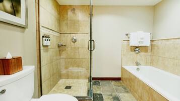 A bathroom with a glass-enclosed shower, a toilet, and a bathtub.