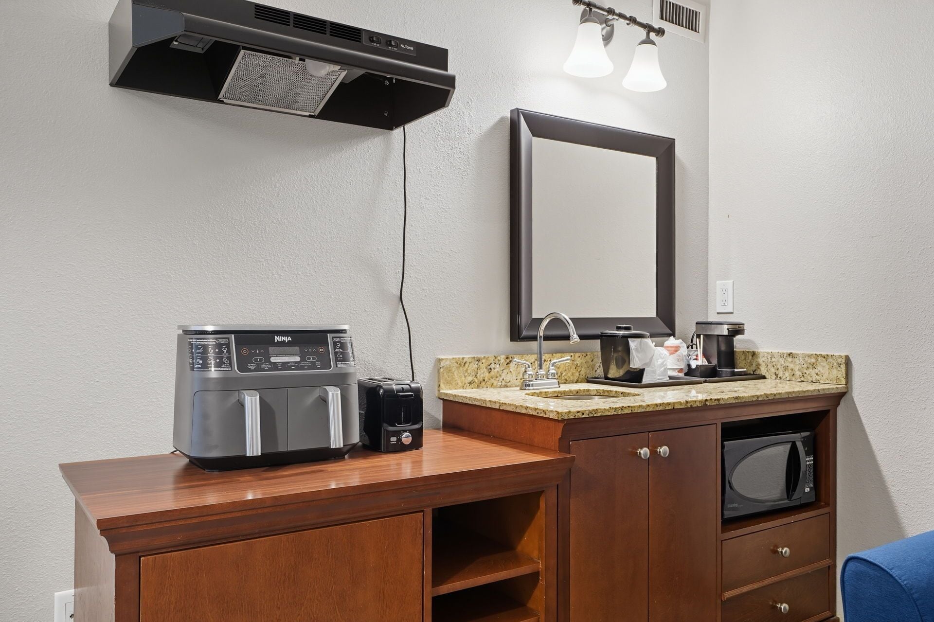 Une petite cuisine équipée d’une machine à café, d’un four à micro-ondes et d’une cafetière.