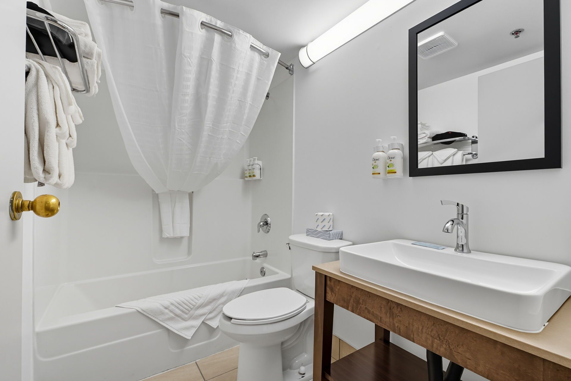 Een moderne badkamer met een bad, toilet en wastafel.