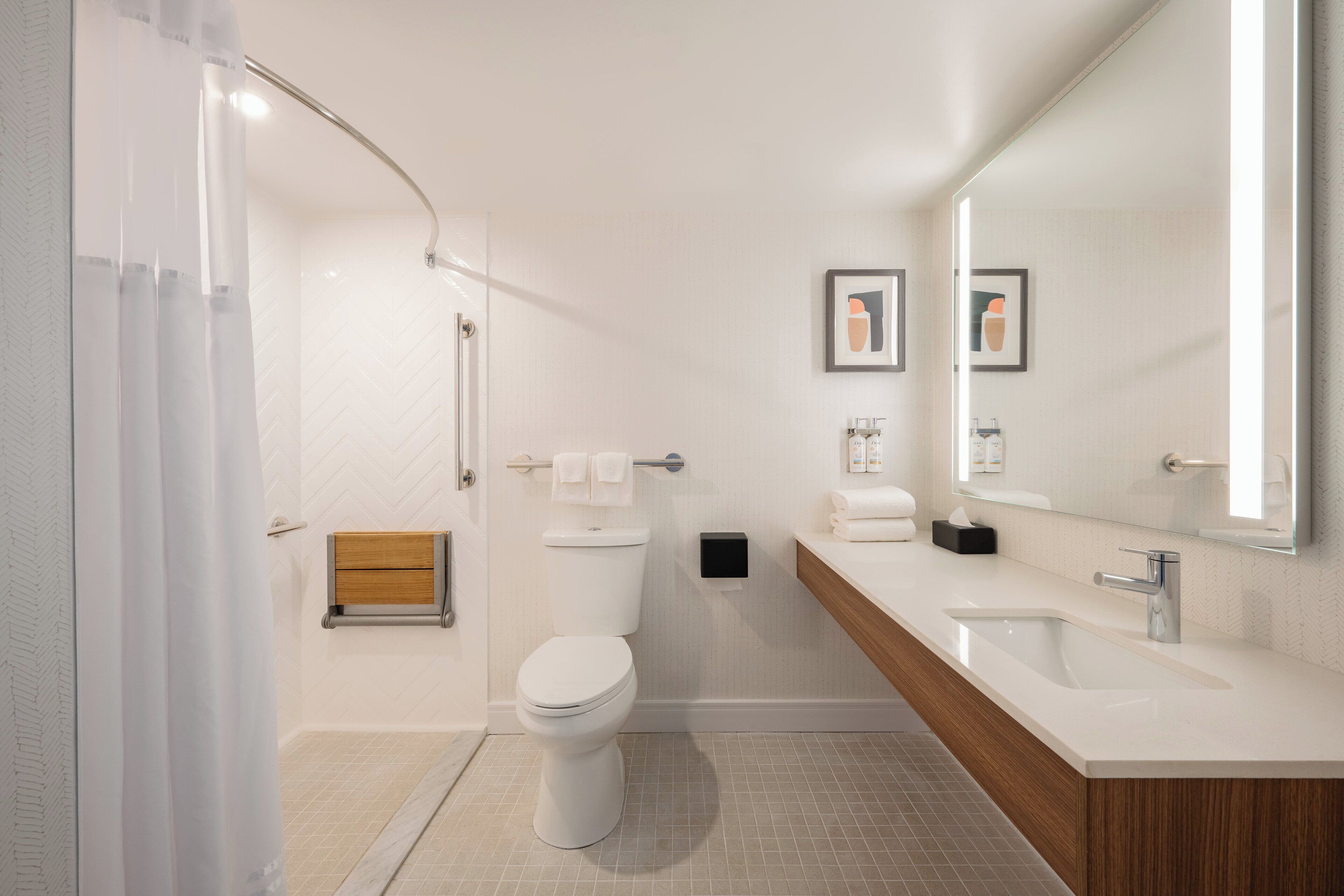 A modern bathroom with a shower, toilet, and two sinks.
