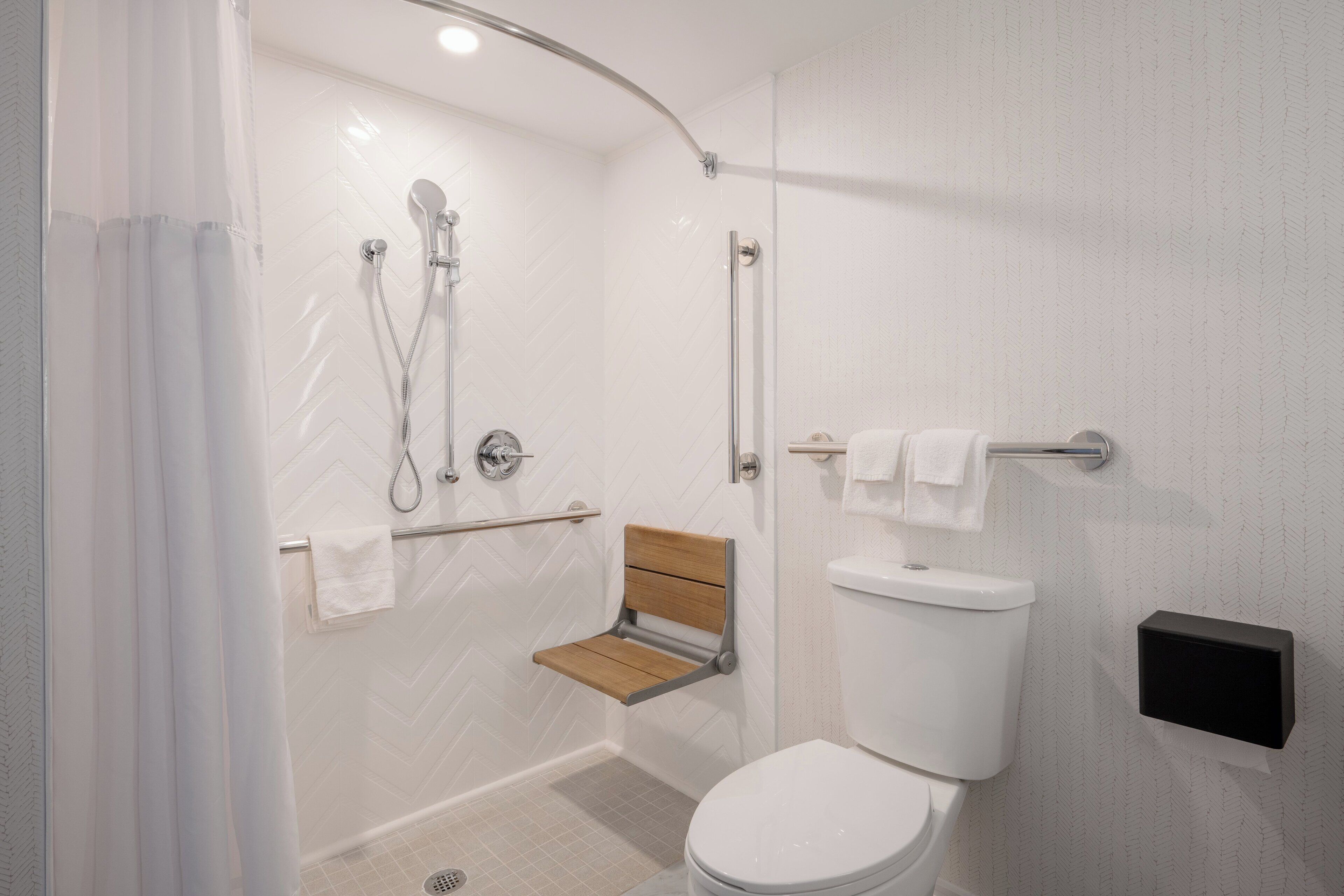 Un baño moderno con ducha, inodoro y estante de madera.