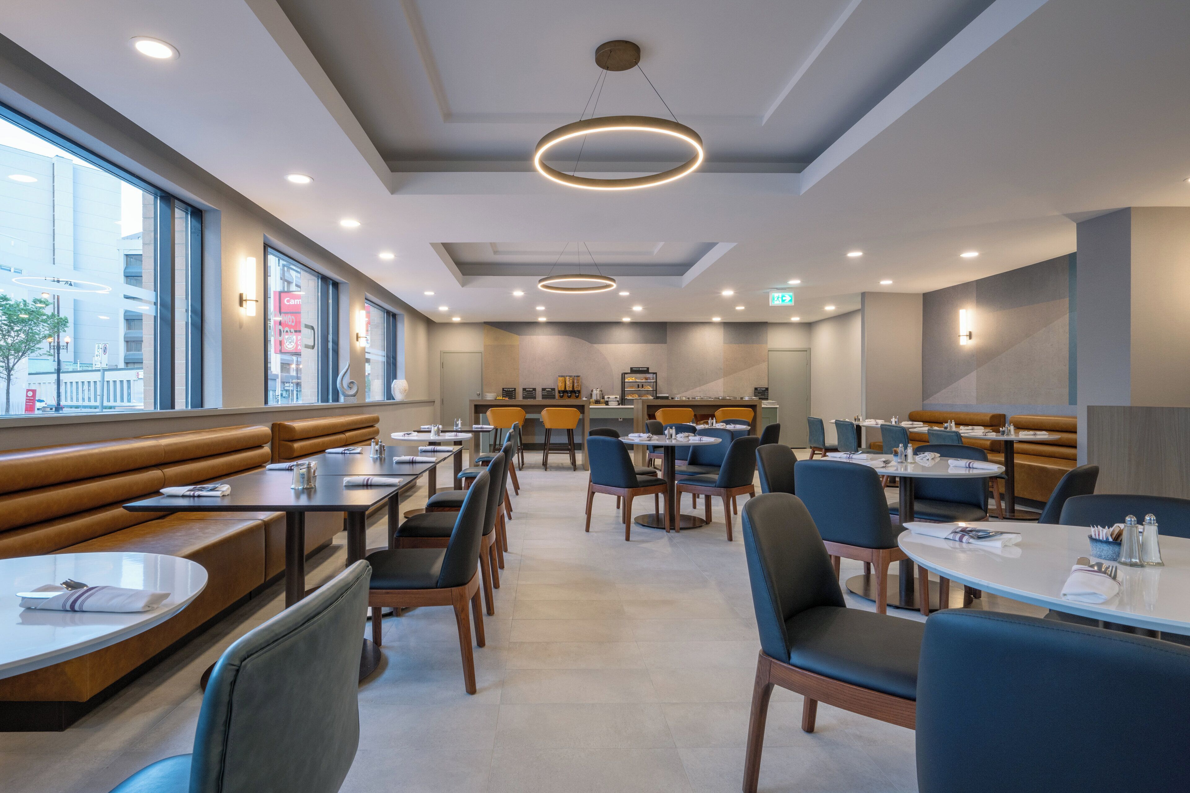 Un ristorante moderno con banconi e tavoli, ampie finestre e un design pulito e contemporaneo.