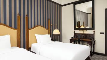 A hotel room with two beds, a desk, a chair, a lamp, and a large mirror.