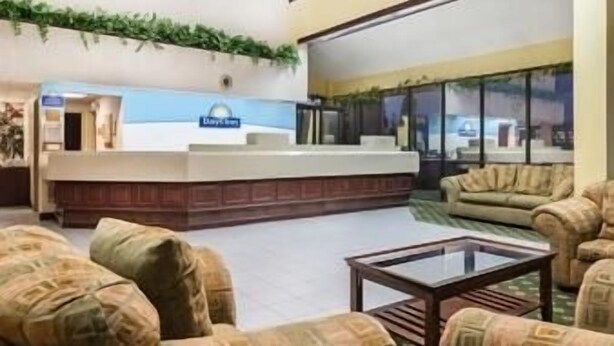 A hotel lobby with a reception desk, seating area, and large windows. - Days Inn by Wyndham Indianapolis/Castleton (Indianapolis)