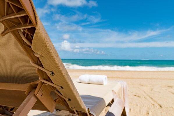 靠近海滩、沙滩椅、海滩遮阳伞、沙滩毛巾