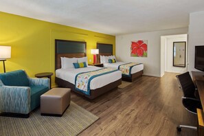Habitación de hotel con dos camas, un sofá, un escritorio y un televisor.