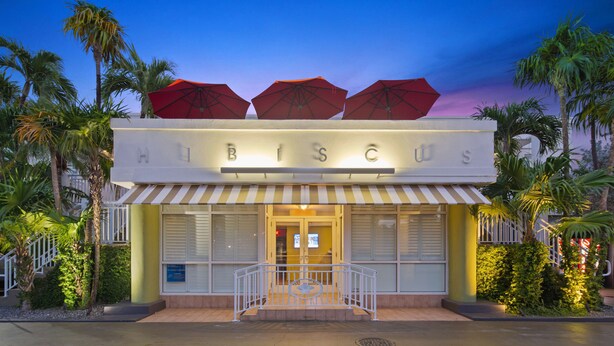 A building with a sign reading "HUBISCO" and a striped awning. - Best Western Hibiscus Motel (Key West)