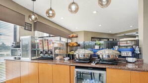 A modern kitchen with a granite countertop, stainless steel appliances, and a glass display case.