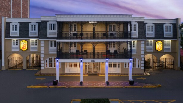 A hotel with a double-story facade, a balcony on the second floor, and a sign with the number 6322. - Super 8 by Wyndham New Orleans (New Orleans)