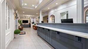A modern kitchen with a long counter, built-in appliances, and a TV mounted on the wall. - Super 8 by Wyndham New Orleans (New Orleans)