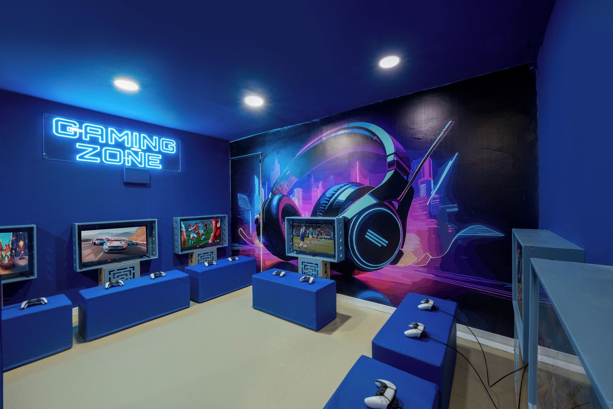 Un espace de jeux avec des enseignes au néon, plusieurs postes de jeu et une grande fresque murale.