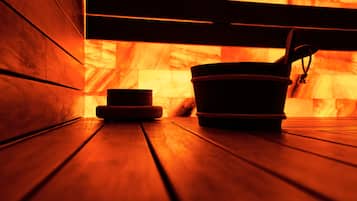 A sauna with wooden benches and a bucket.