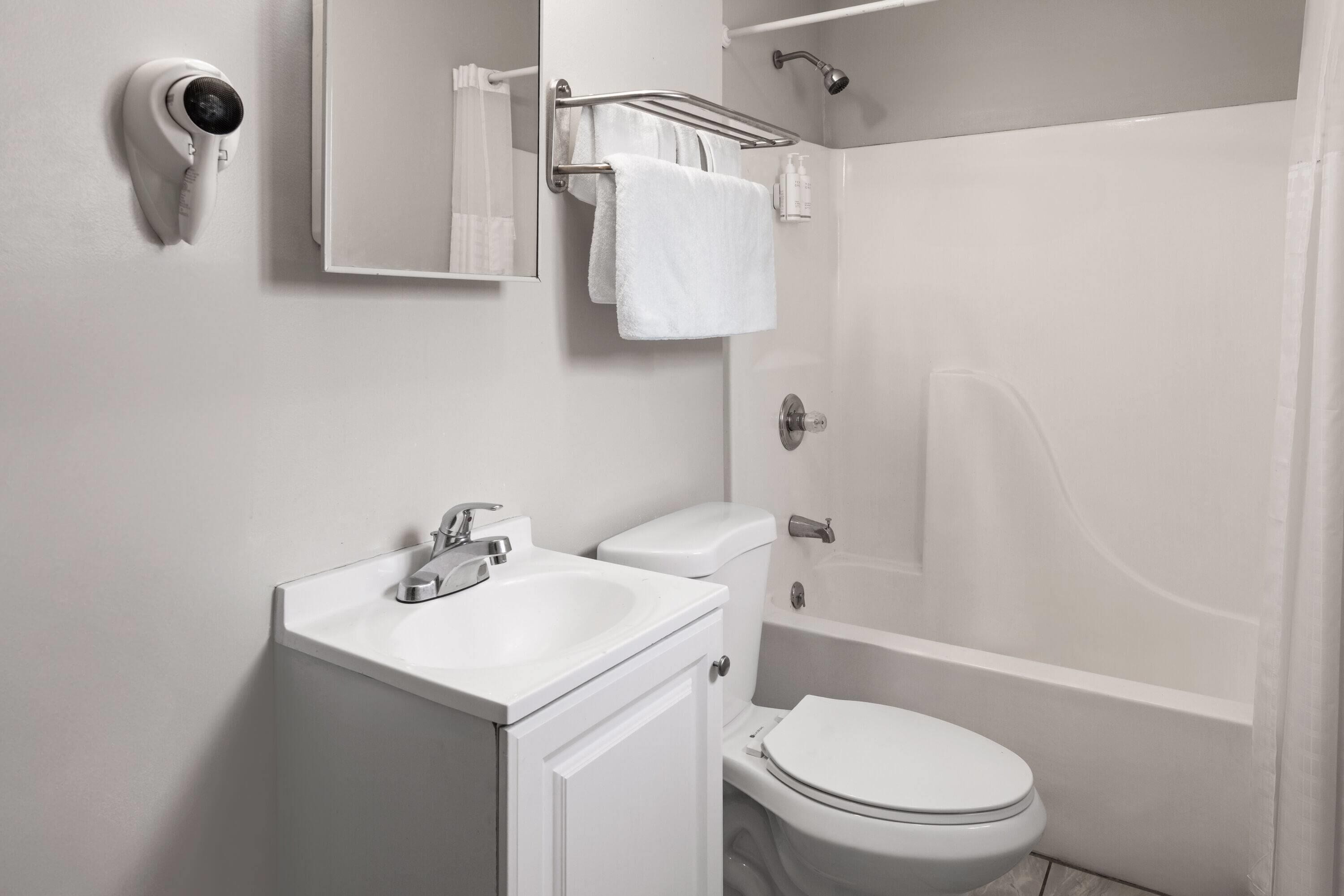 Un baño moderno con inodoro, lavamanos y ducha.
