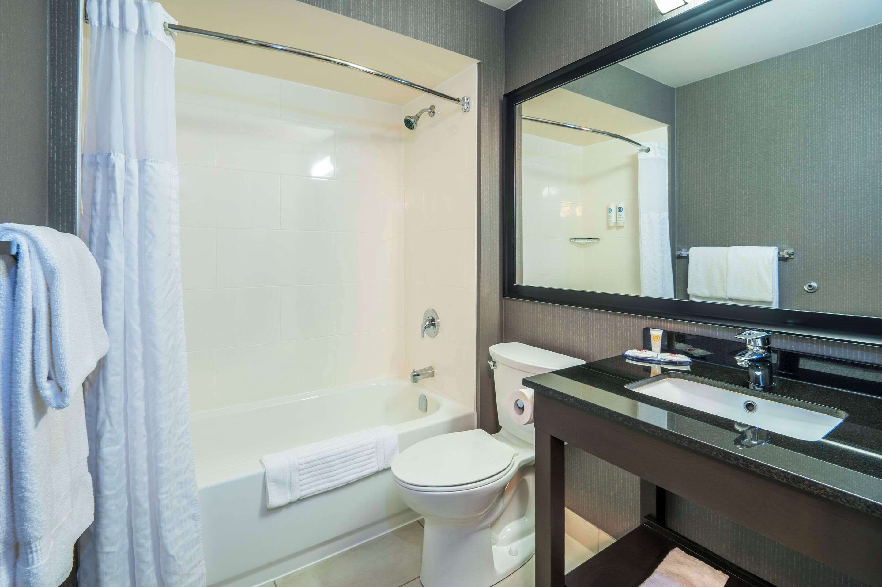 A modern bathroom with a bathtub, toilet, and sink.