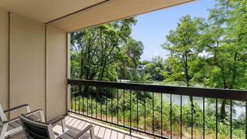Un balcon donnant sur un lac et des arbres.