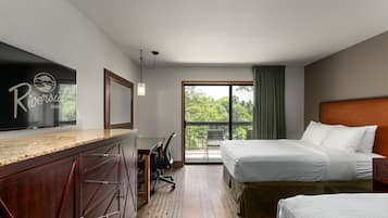 A hotel room with a bed, a desk, a chair, and a large window.