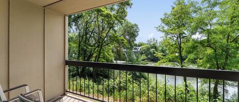 Un balcon avec vue sur un lac et des arbres.